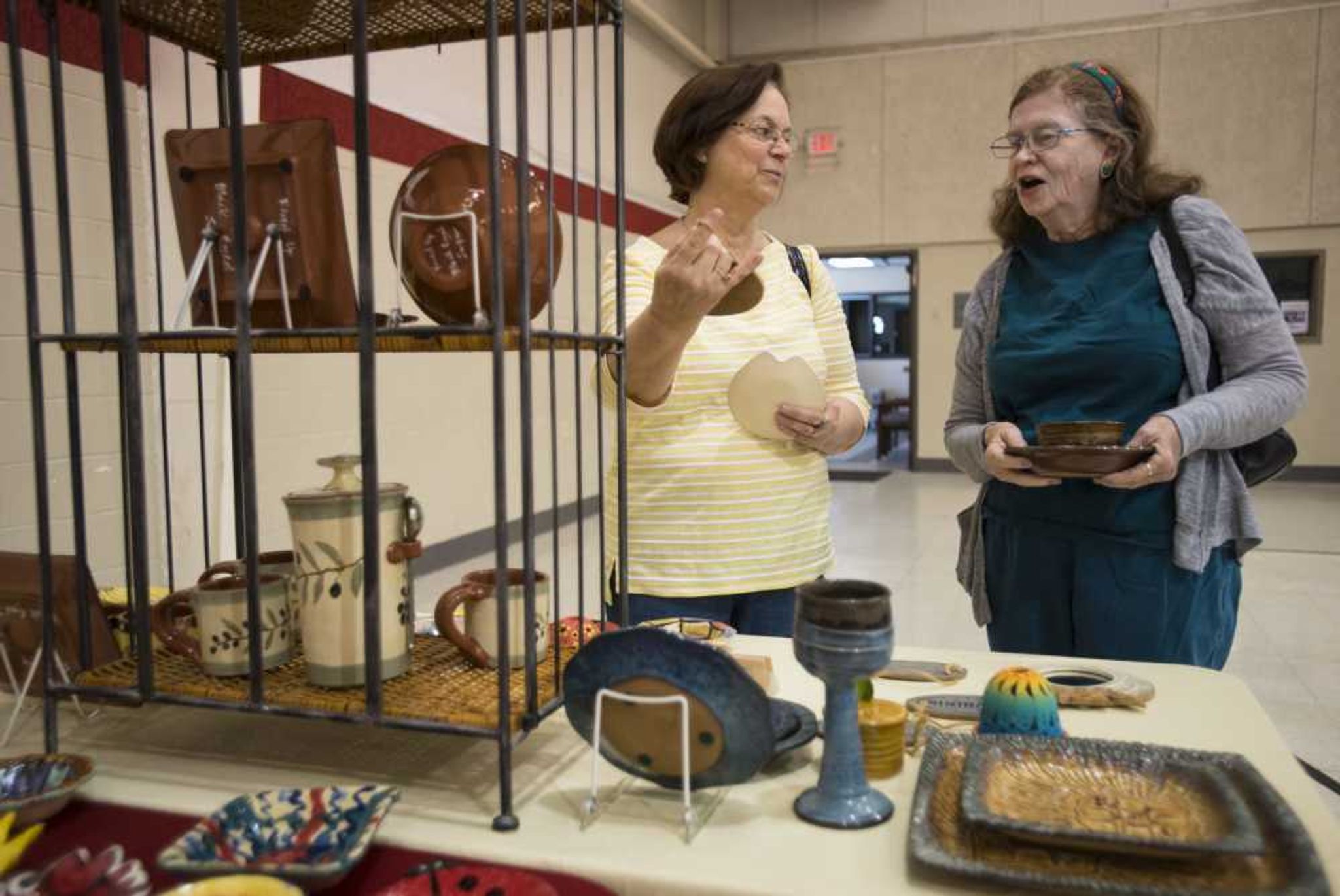 Avon Crocker, left, laughs with Marilou Shaner after reading an inscription on a bowl at an Empty Bowls Banquet on Sunday at the Salvation Army in Cape Girardeau.
