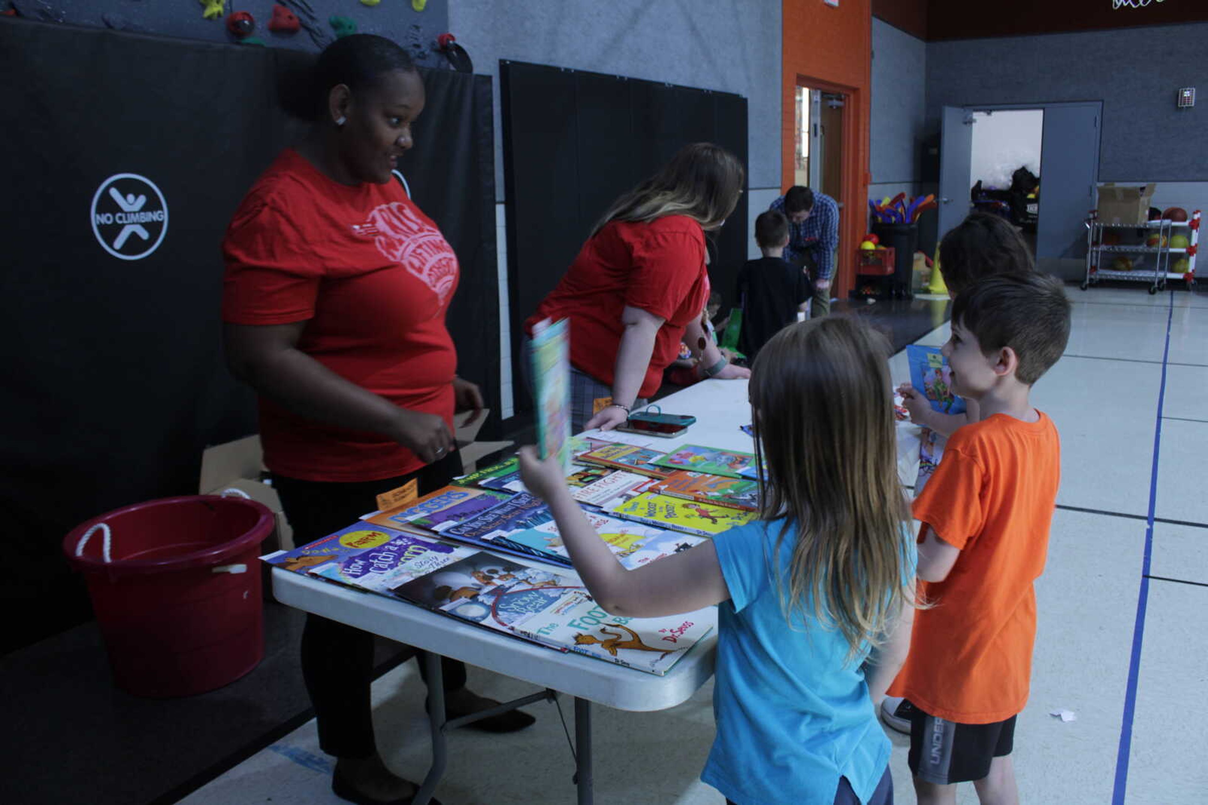 Senior early childhood education majors Erin King (right) and Bridgette Berner (left) hand out candy and books to students after completing the literacy walk. King is the public relations manager for SMSTA and Berner is the vice president.