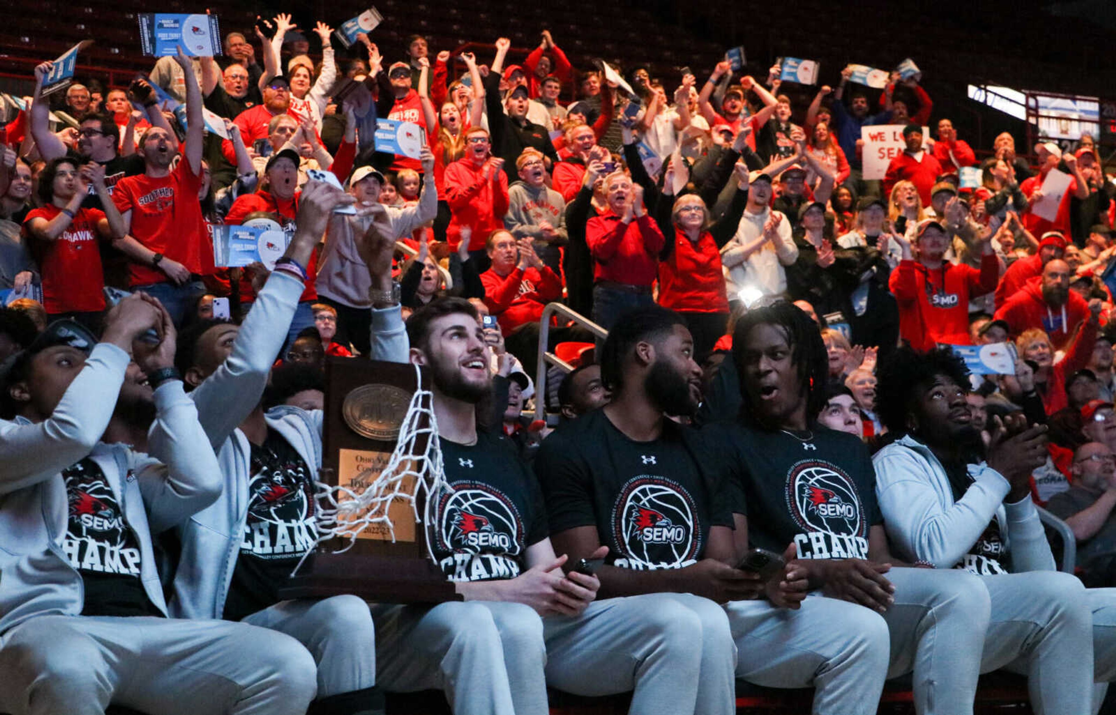 The SEMO men's basketball team cheer in reaction to the announcement of their first four matchup opponent while fans cheer behind them. The team was attending the Selection Sunday public showing event at the Show Me Center in Cape Girardeau Missouri on March 12, 2023.