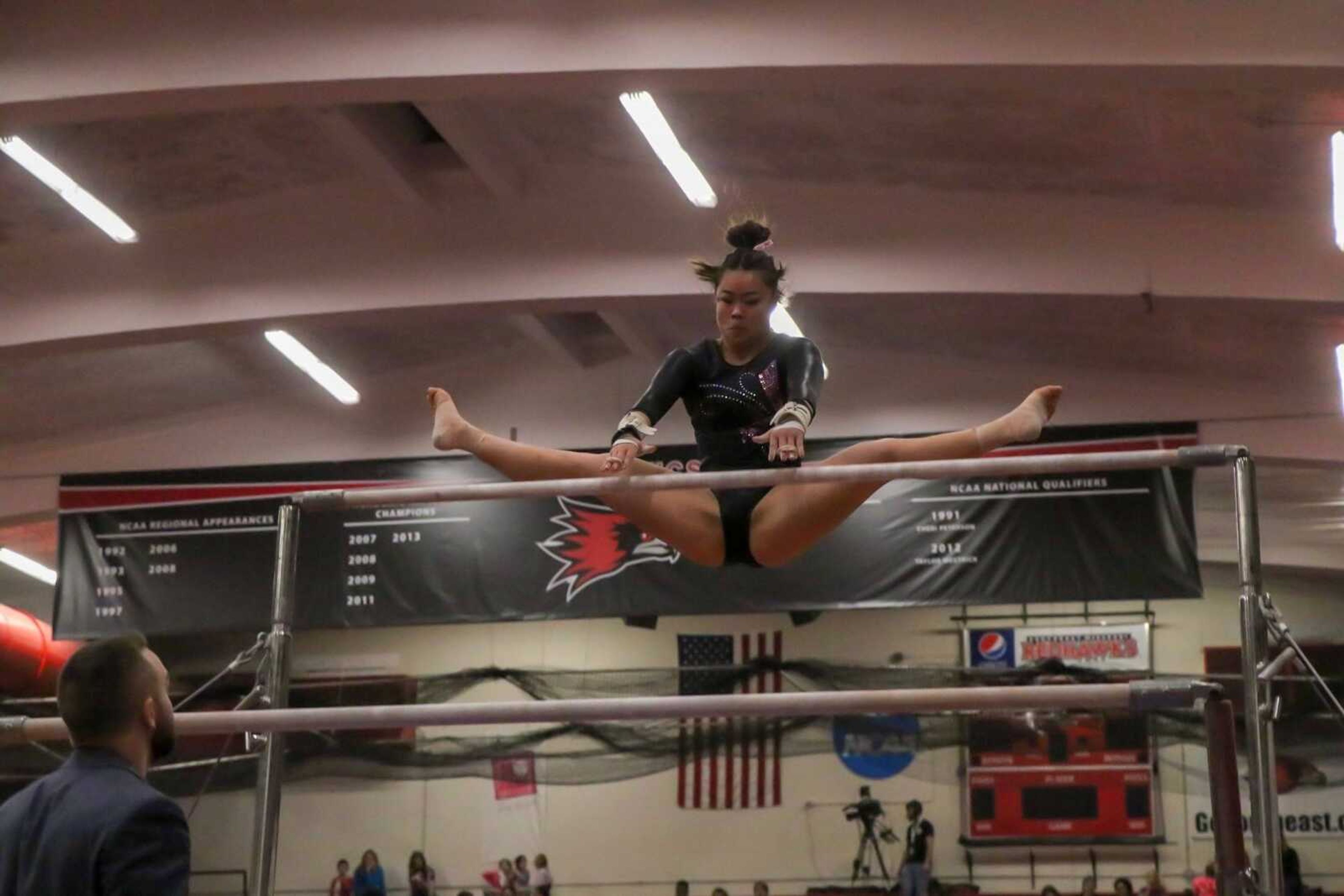 Sophomore gymnast Alana Fischer transitions on the uneven bars in a Feb. 8 meet at Houck Field House.