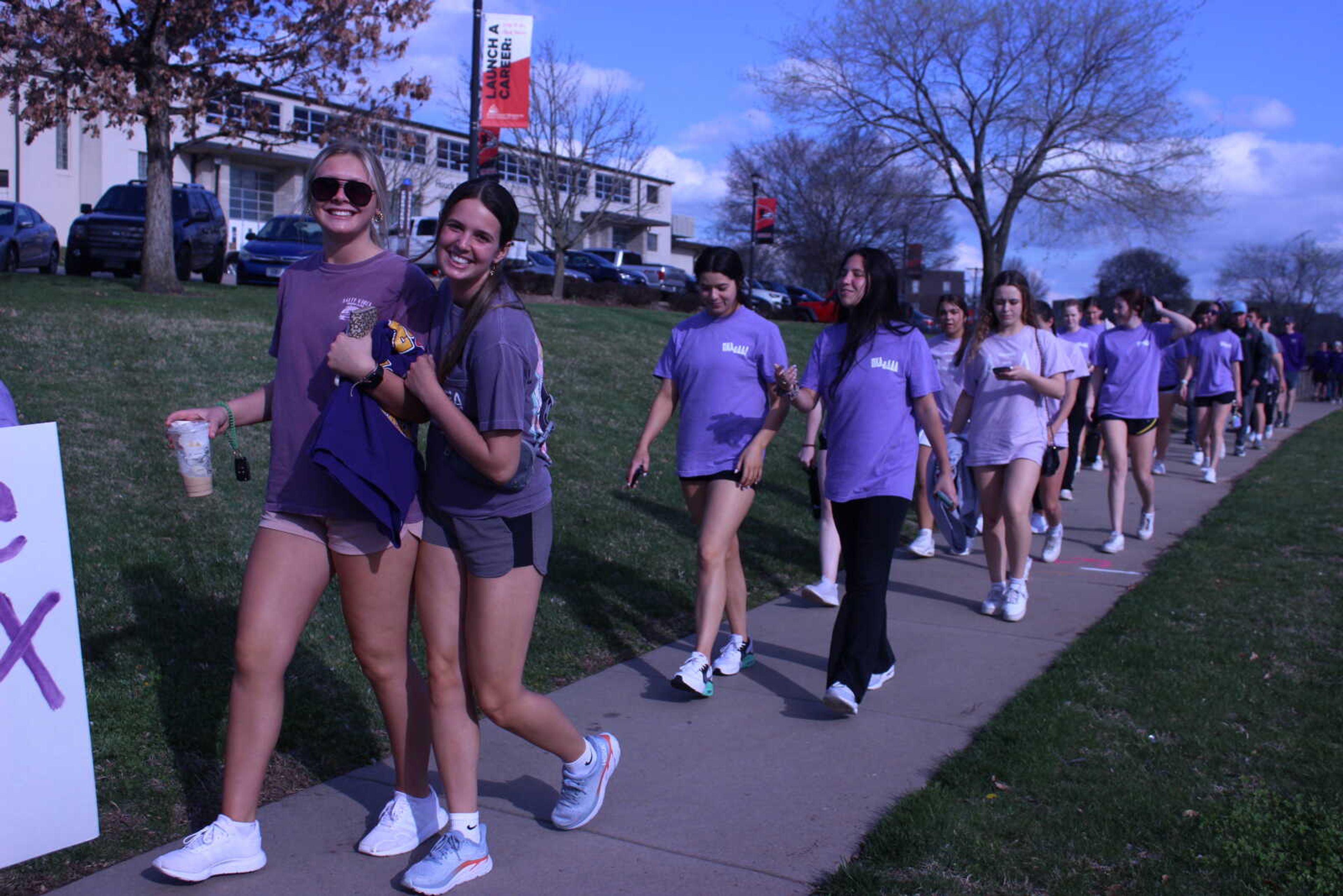 Greek students walk along Broadway Street at the annual Walk a Mile in Their Shoes event on Tuesday, April 5. The event is part of Greek Week.