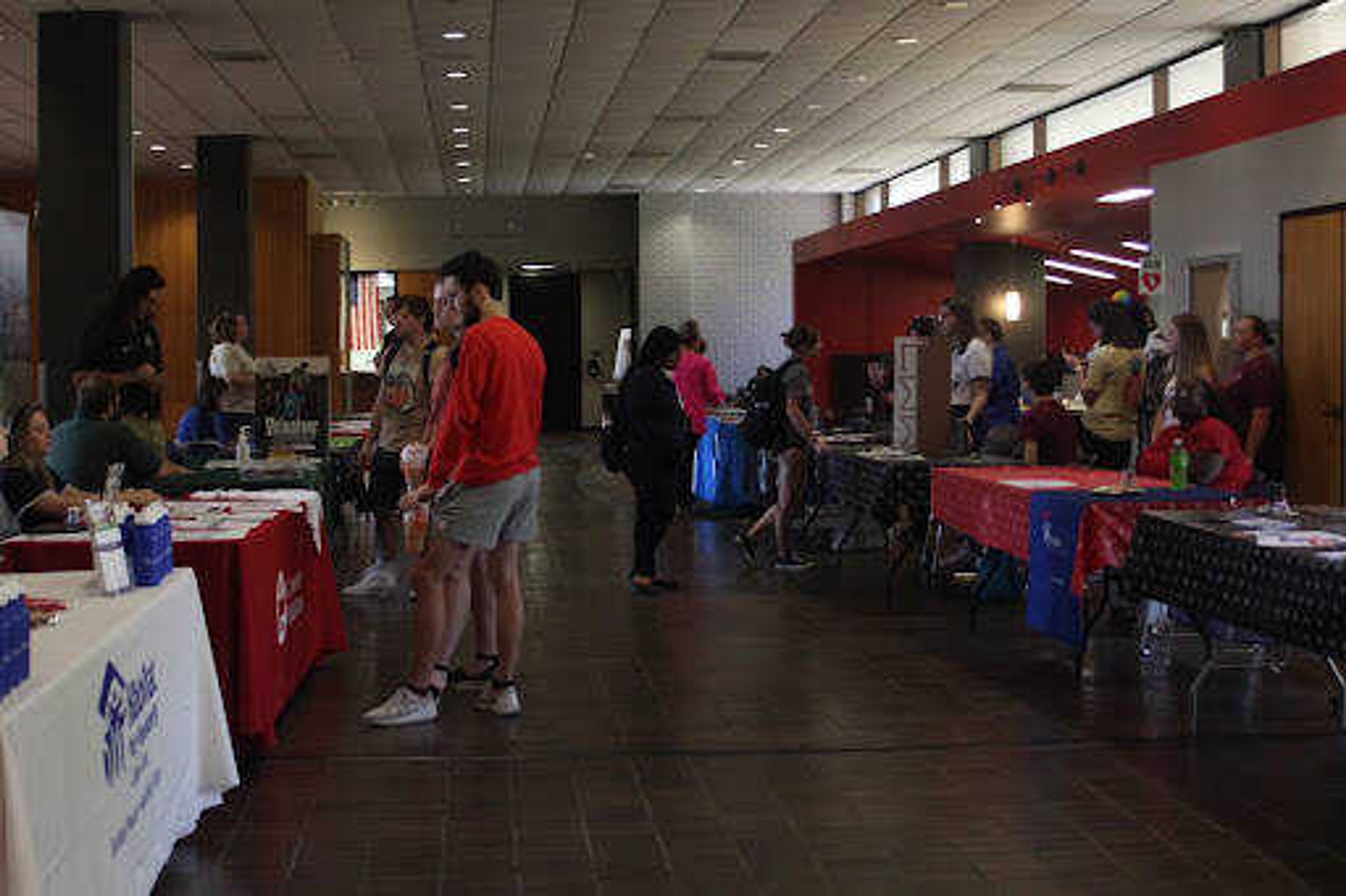 Students gather around organizations’ booths to learn about different ways to volunteer. On the left, students speak to the American Red Cross.