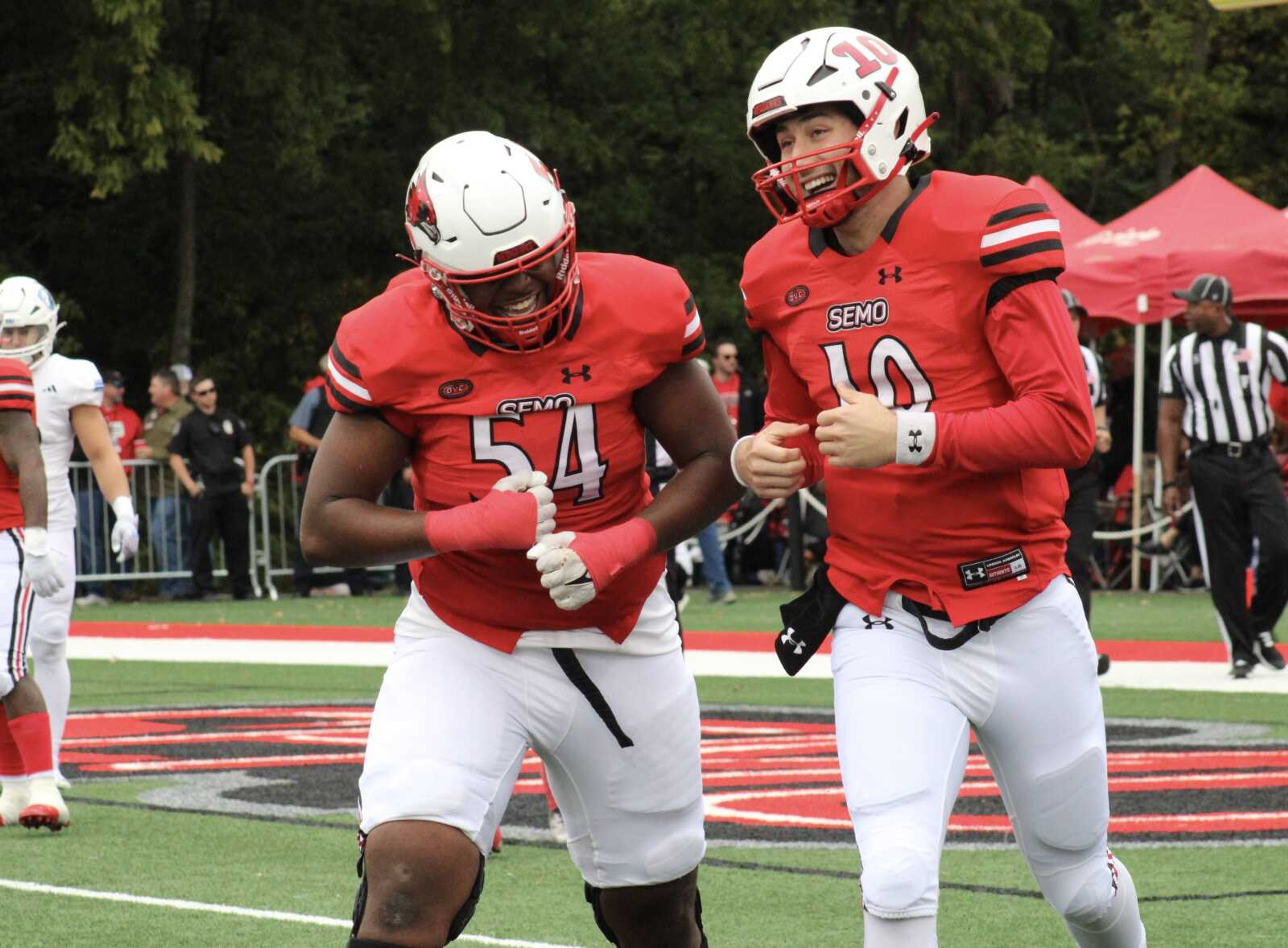 Junior offensive lineman Marshakie Applewhite (54) and junior quarterback Paxton DeLaurent (10) celebrate after DeLaurent scores a touchdown in Saturday’s matchup with EIU. The Redhawks came out on top 35-28.