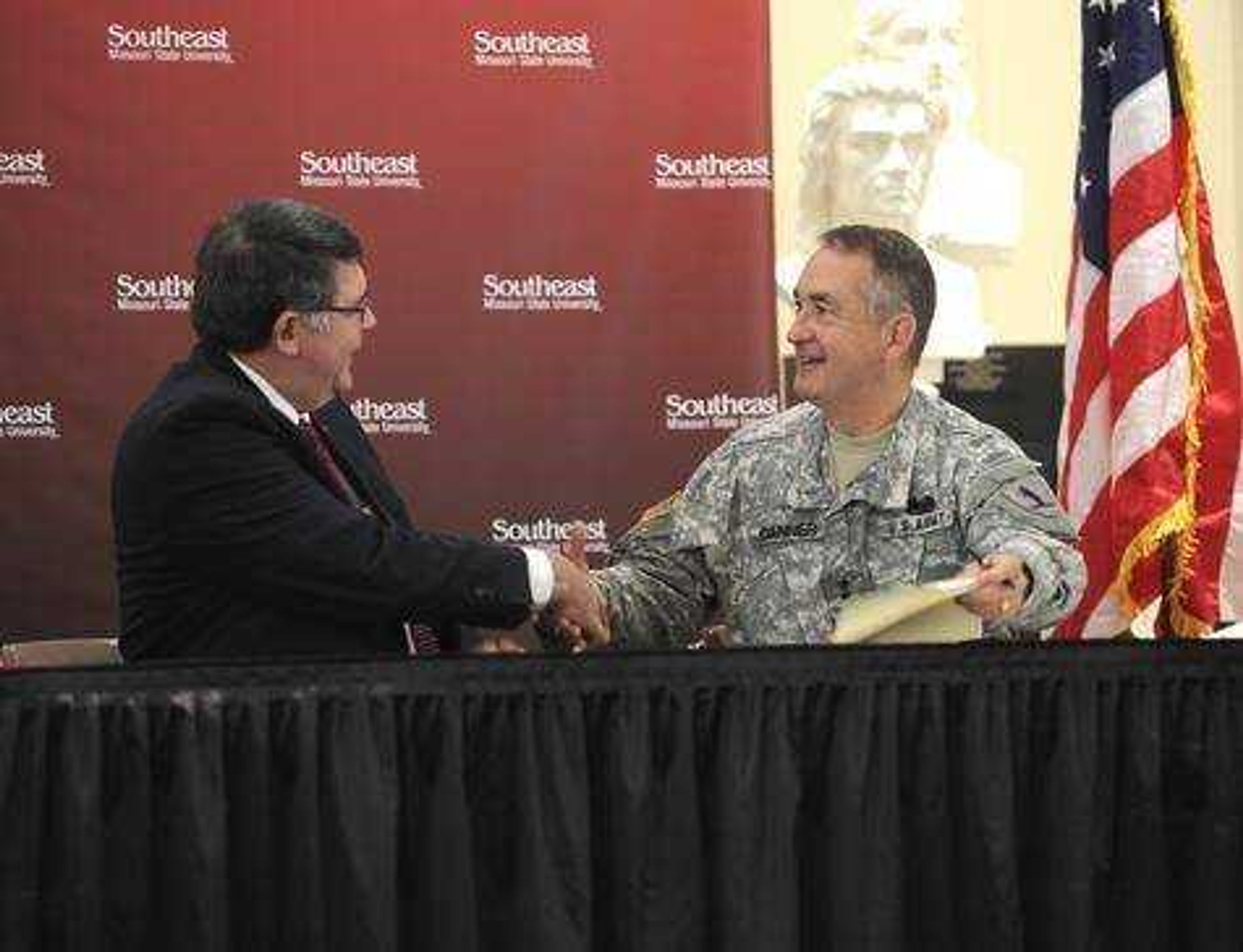 Dr. Kenneth W. Dobbins shakes hands with Maj. Gen. Stephen L. Danner, adjutant general of the Missourri Army NAtional Guard, after signing agreement to launch Show Me Gold Officer Leadership Program. Southeast Missourian photo.