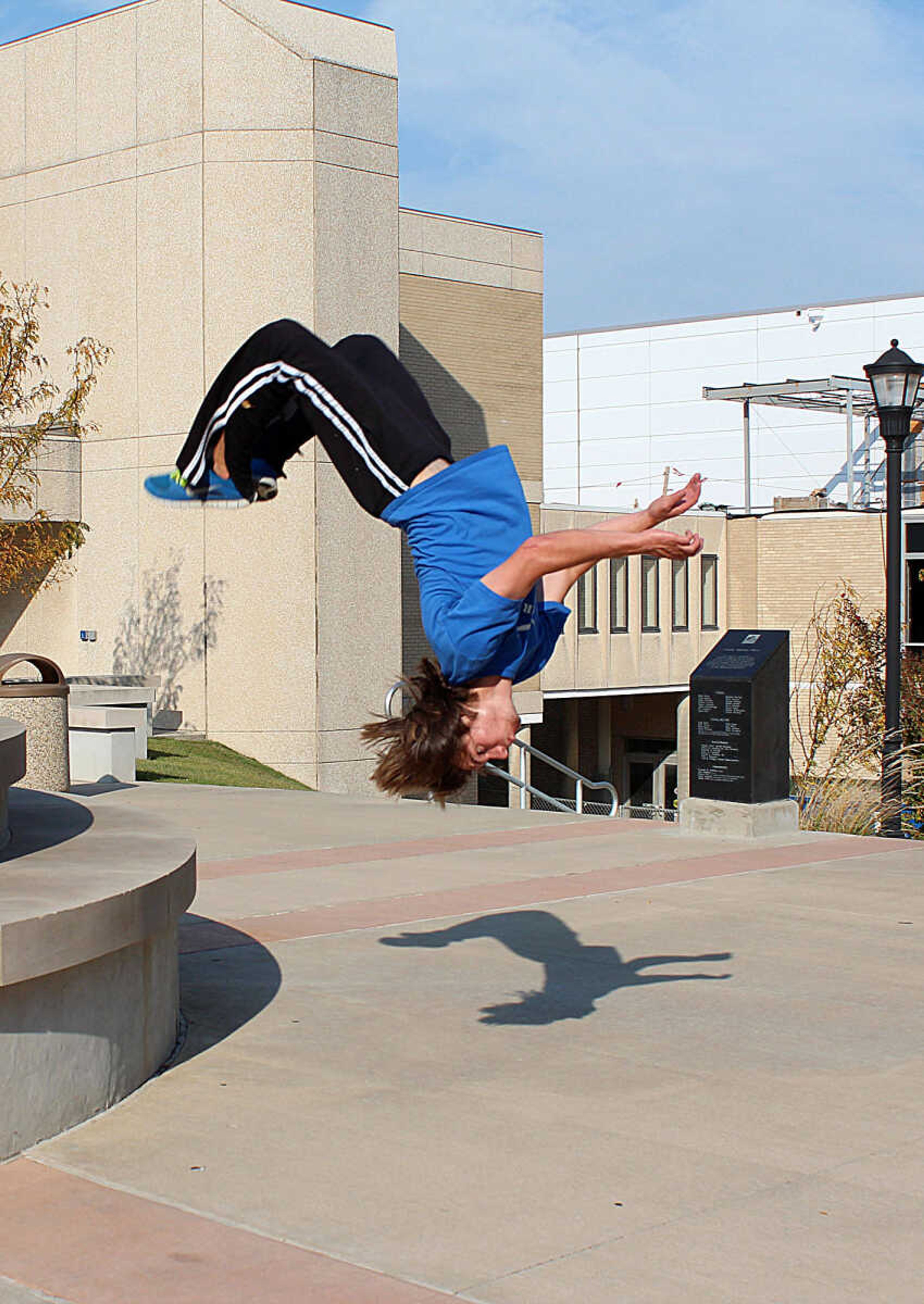 Sophomore Kyle Thies, president and founder of the Parkour and Free-Running Club, shows off his skills by doing a back flip off the fountain in front of Dempster Hall. Photo by Ashley Reed