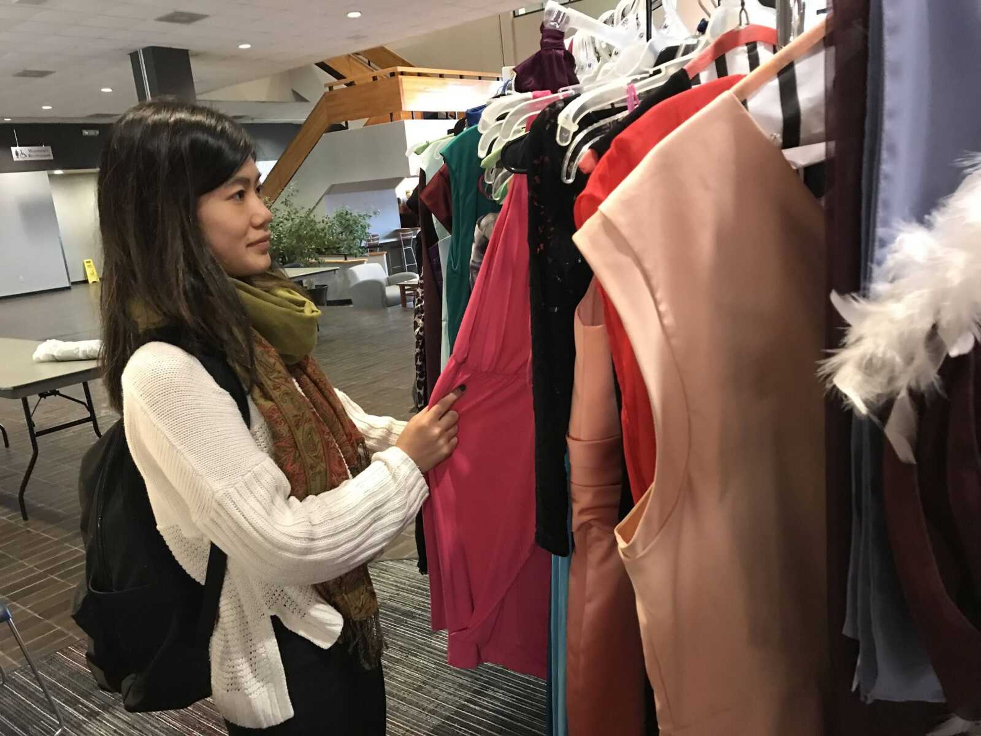 Yuka Sugiura, sophomore, shops for a second time at the sixth annual dress sale Friday, Oct. 19.