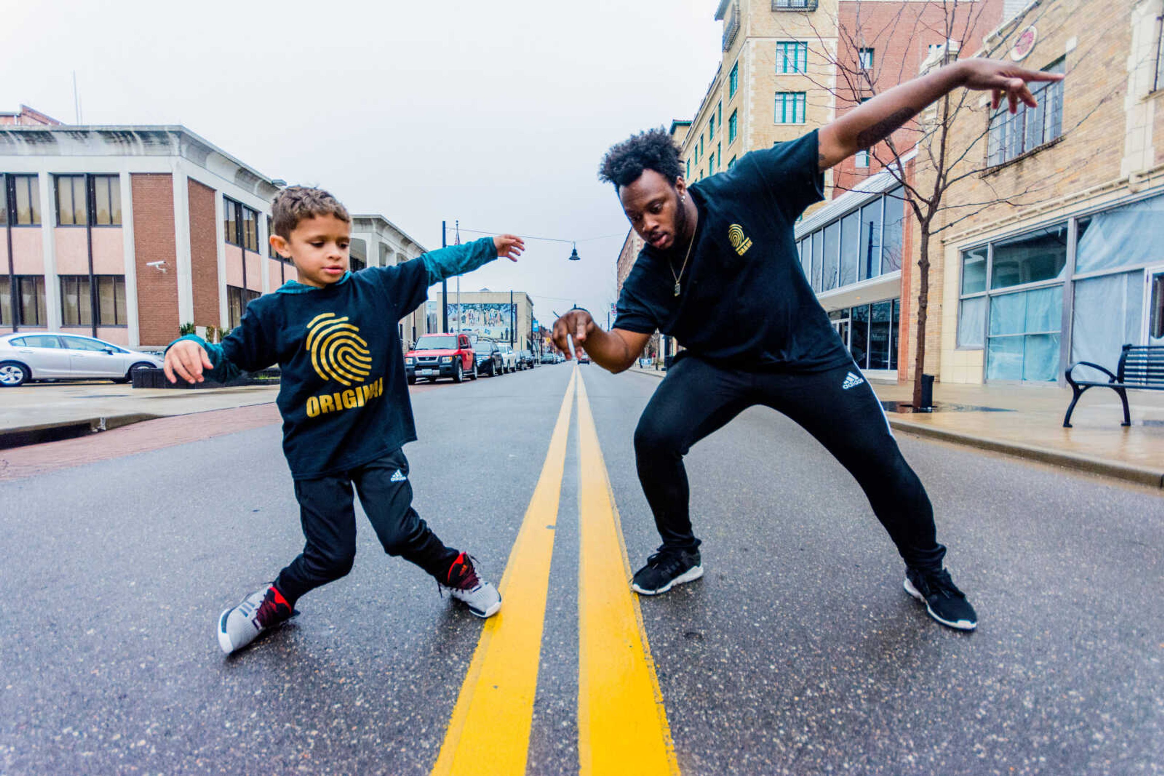 Christopher Guada, left and his teacher Micheal "Crank" Curry, right, dance in the middle of Broadway Street in downtown Cape Girardeau.