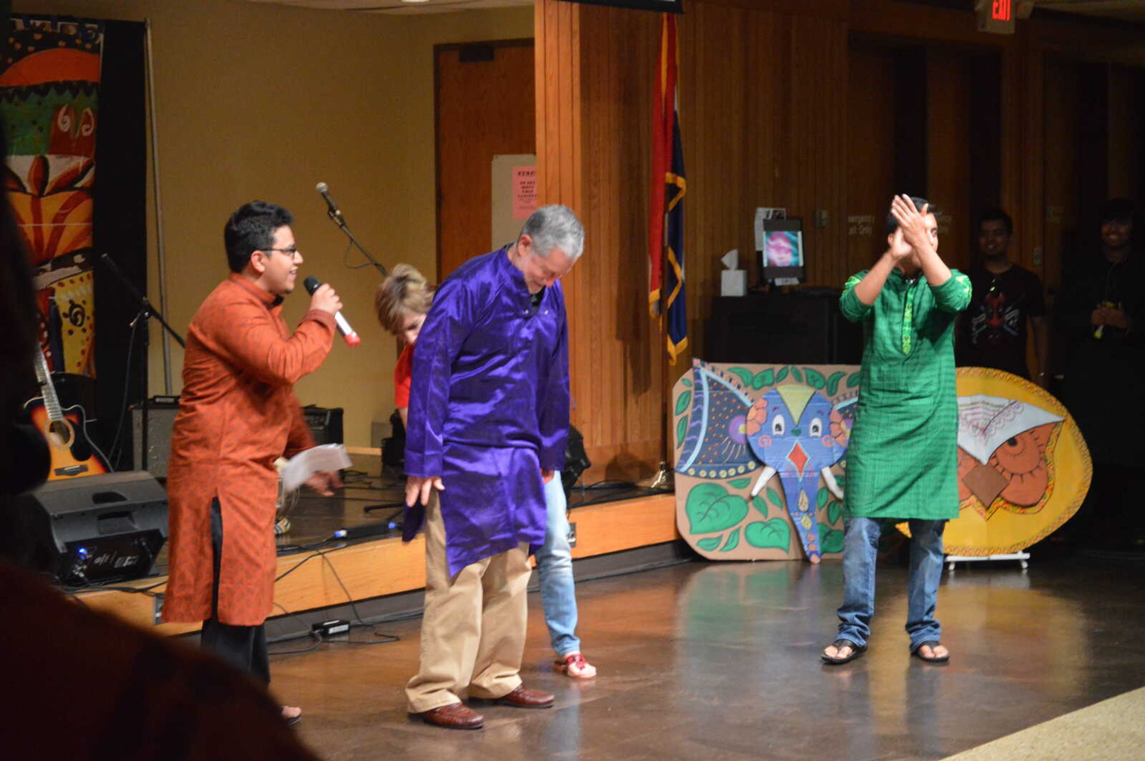 Dr. Vargas puts on the panjabi with the help of his wife.