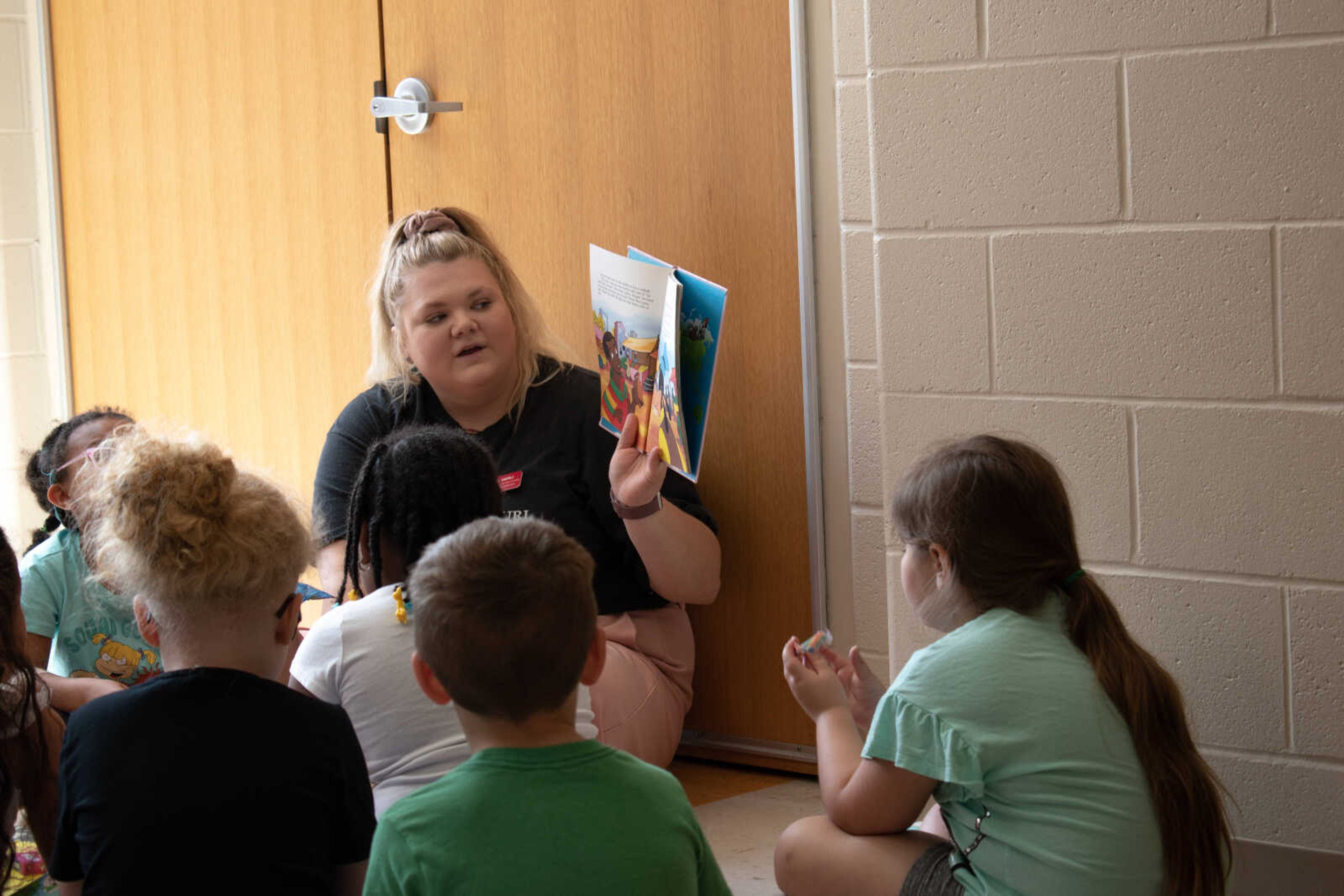 Early Elementary Education Major and SMSTA PR Exec Jordan Merli reads to students after completing the literacy walk. Students ate candy and listened to Merli's story telling. 
