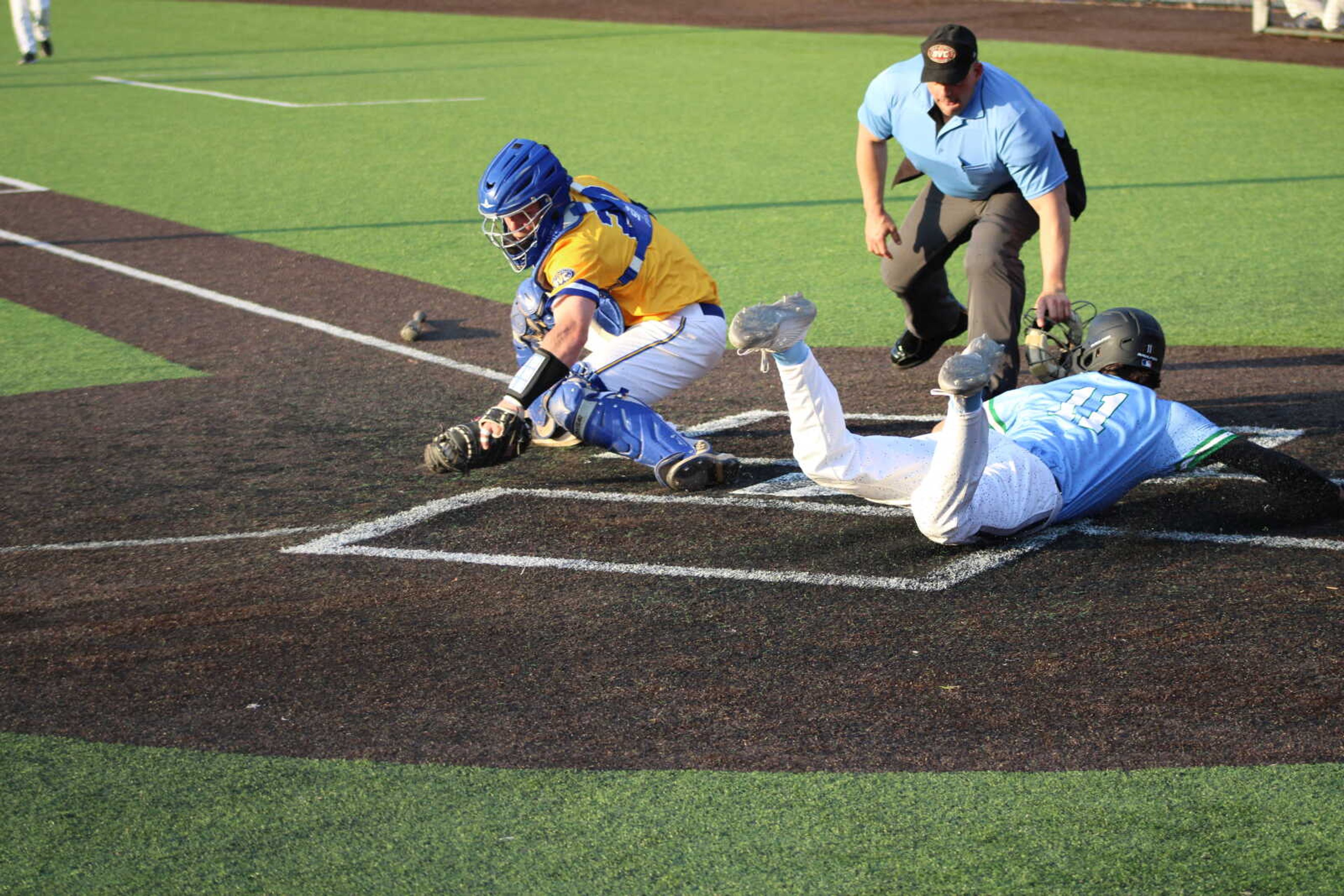 Sophomore second baseman Ben Palmer dives to homeplate to score a run for the Redhawks April 23.