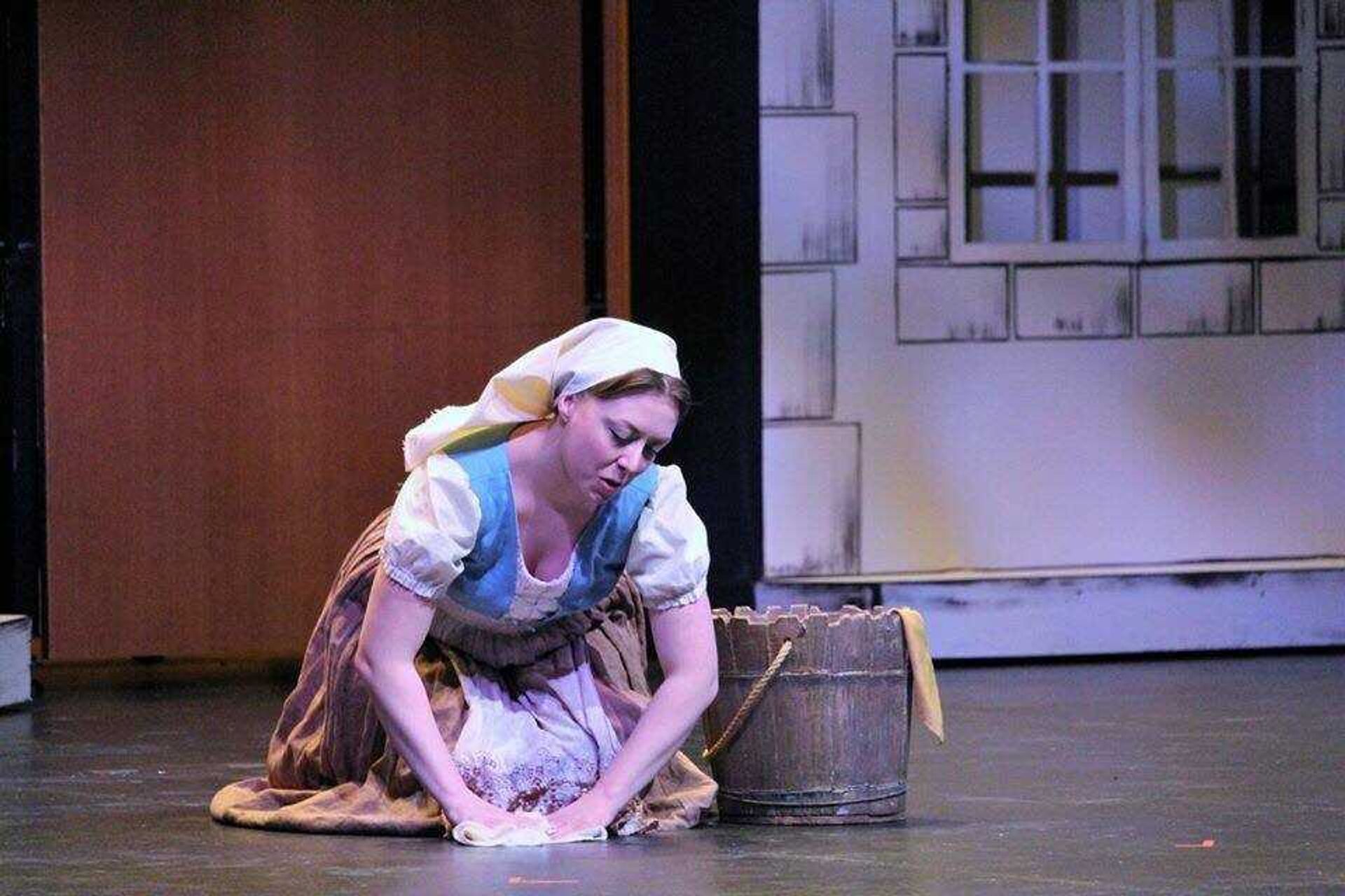 Cinderella, portrayed by Brittany Moleski, scrubs the floor during the opening act of 'Cinderella'
