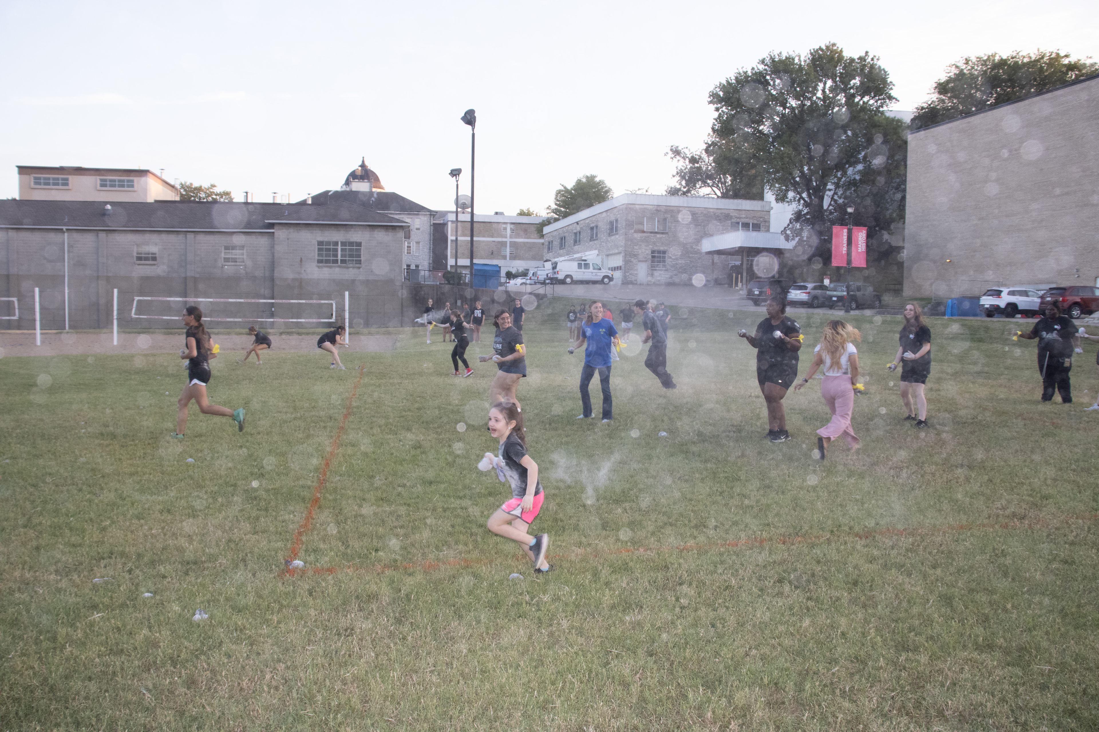 Participants running to throw dust at each other and capture one another's home base.