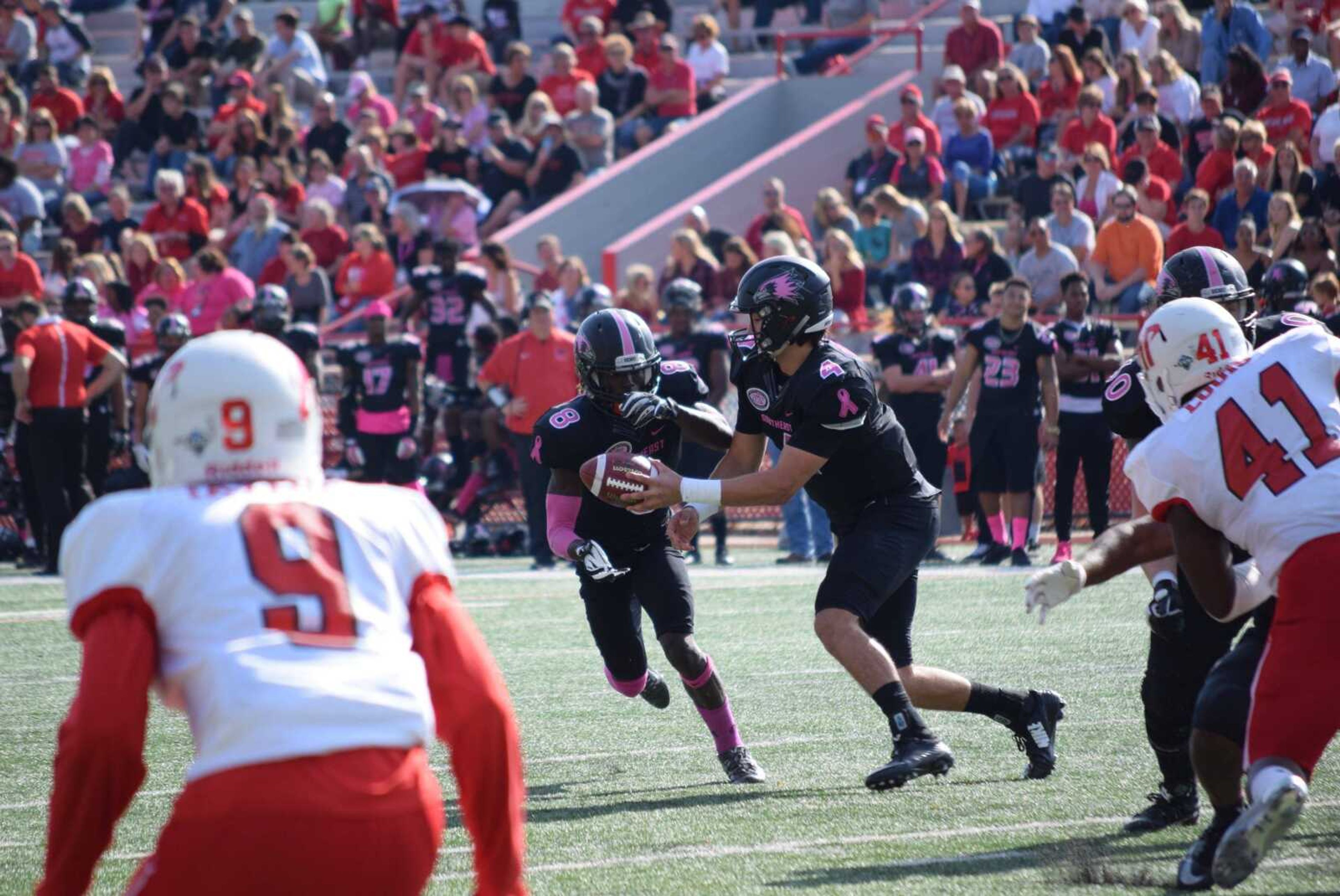 Junior quarterback Jesse Hosket passes the ball to senior running back Tremaine McCullough during last year's Pink Up game.  The date for next year's game has not been decided.