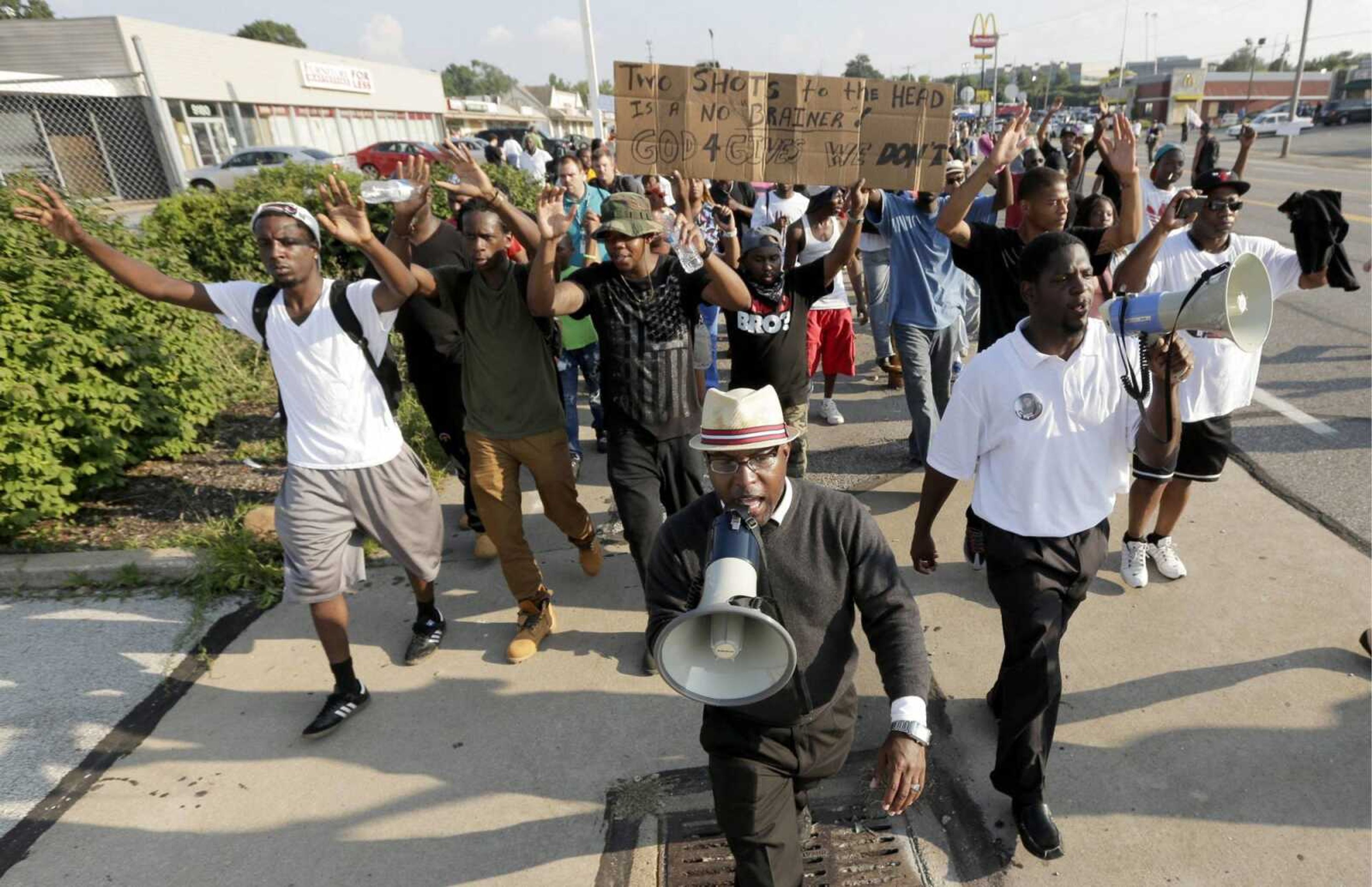 People march during a protest Monday for Michael Brown, who was killed by a police officer Aug. 9 in Ferguson, Mo. Brown's shooting has sparked more than a week of protests, riots and looting in the St. Louis suburb. (AP Photo/Charlie Riedel)