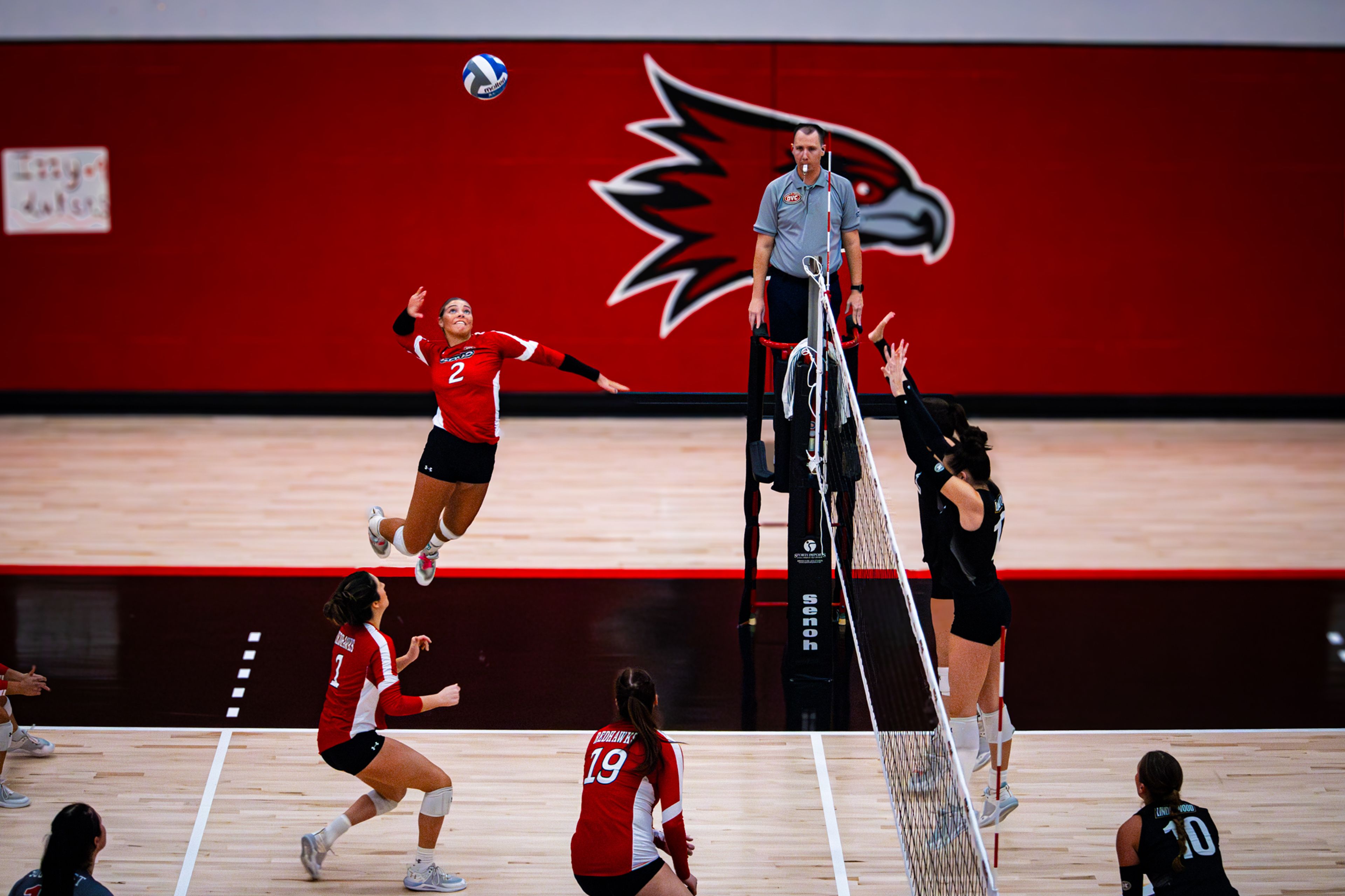 Sophomore outside hitter Lucy Arndt jumps to spike a ball. 