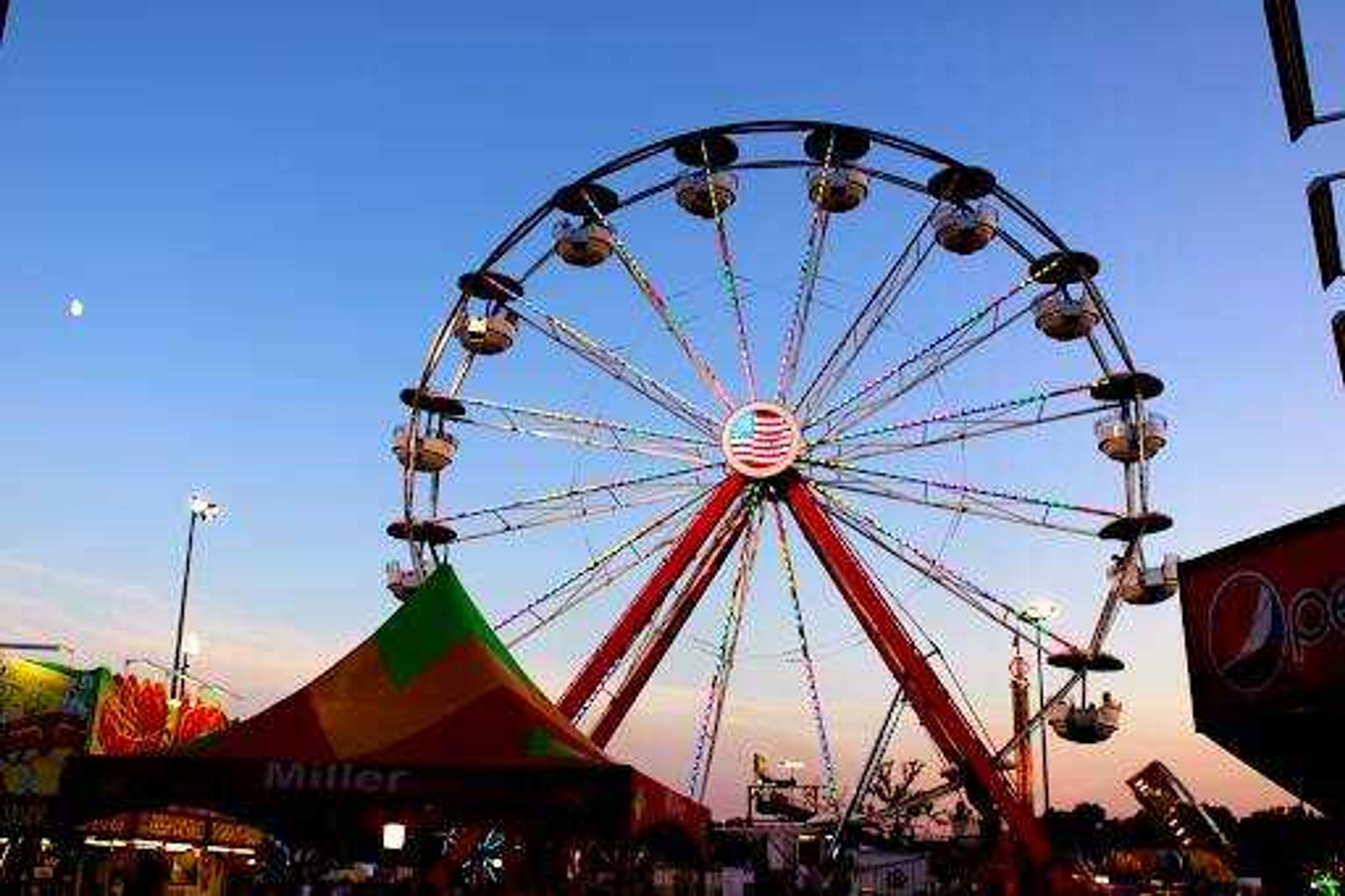 The iconic SEMO District Fair Ferris Wheel lights up the evening at Arena Park Sept. 15. Fair attendees enjoy the end of summer sunset as they wait in line for the rides.