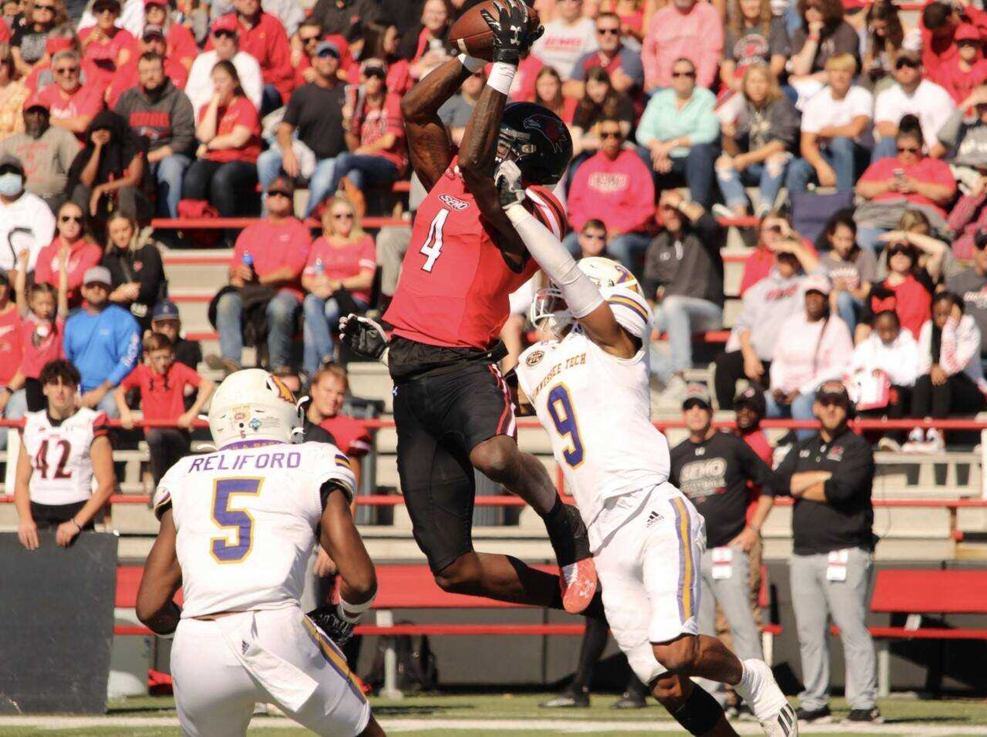 SEMO senior wide receiver Johnny King (4) reaches for a catch over Tennessee Tech sophomore defensive back Trace Danley (9).