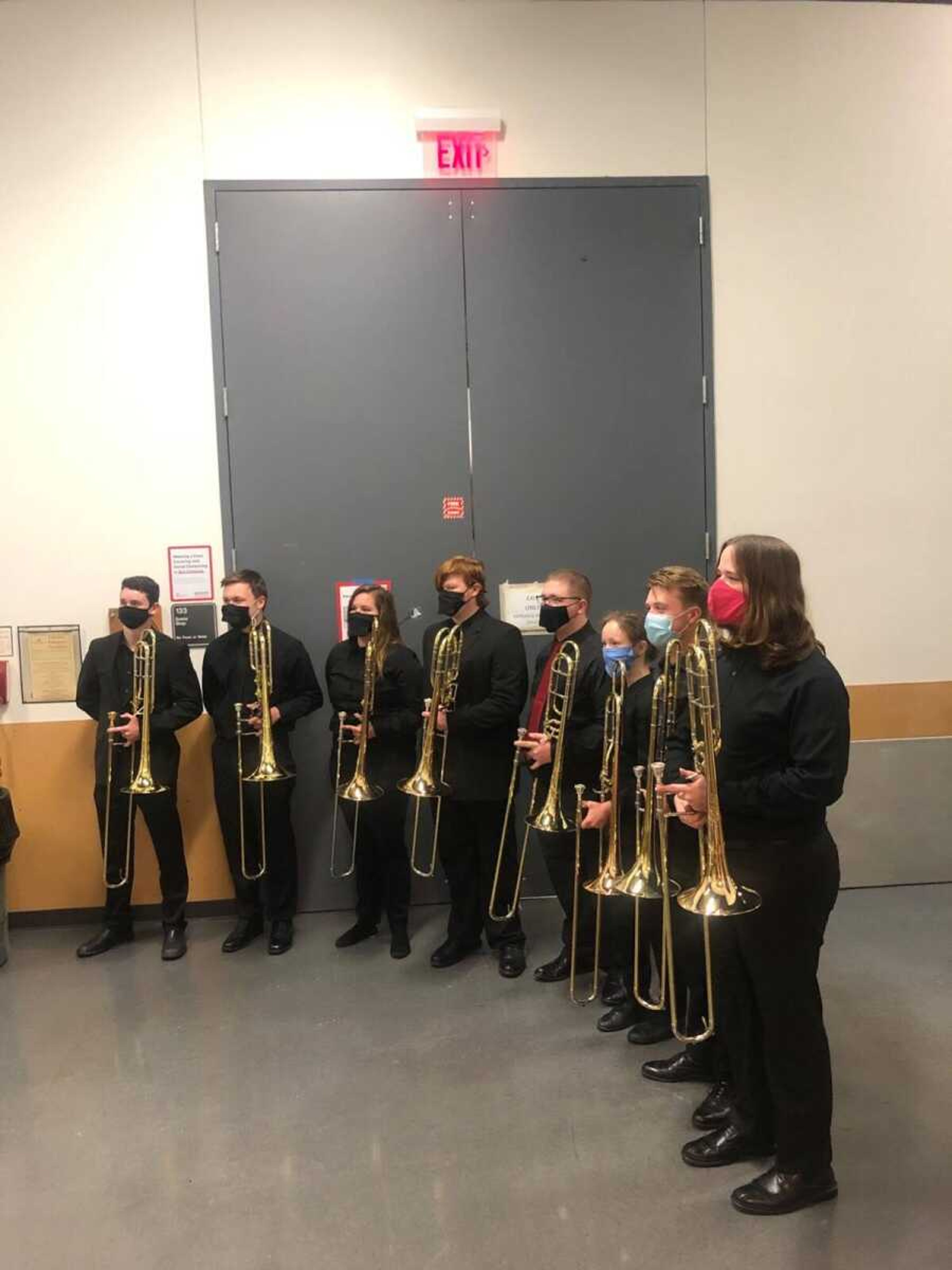 The Wind Symphony bass trombone players come together to take a picture at the end of their Series II concert.