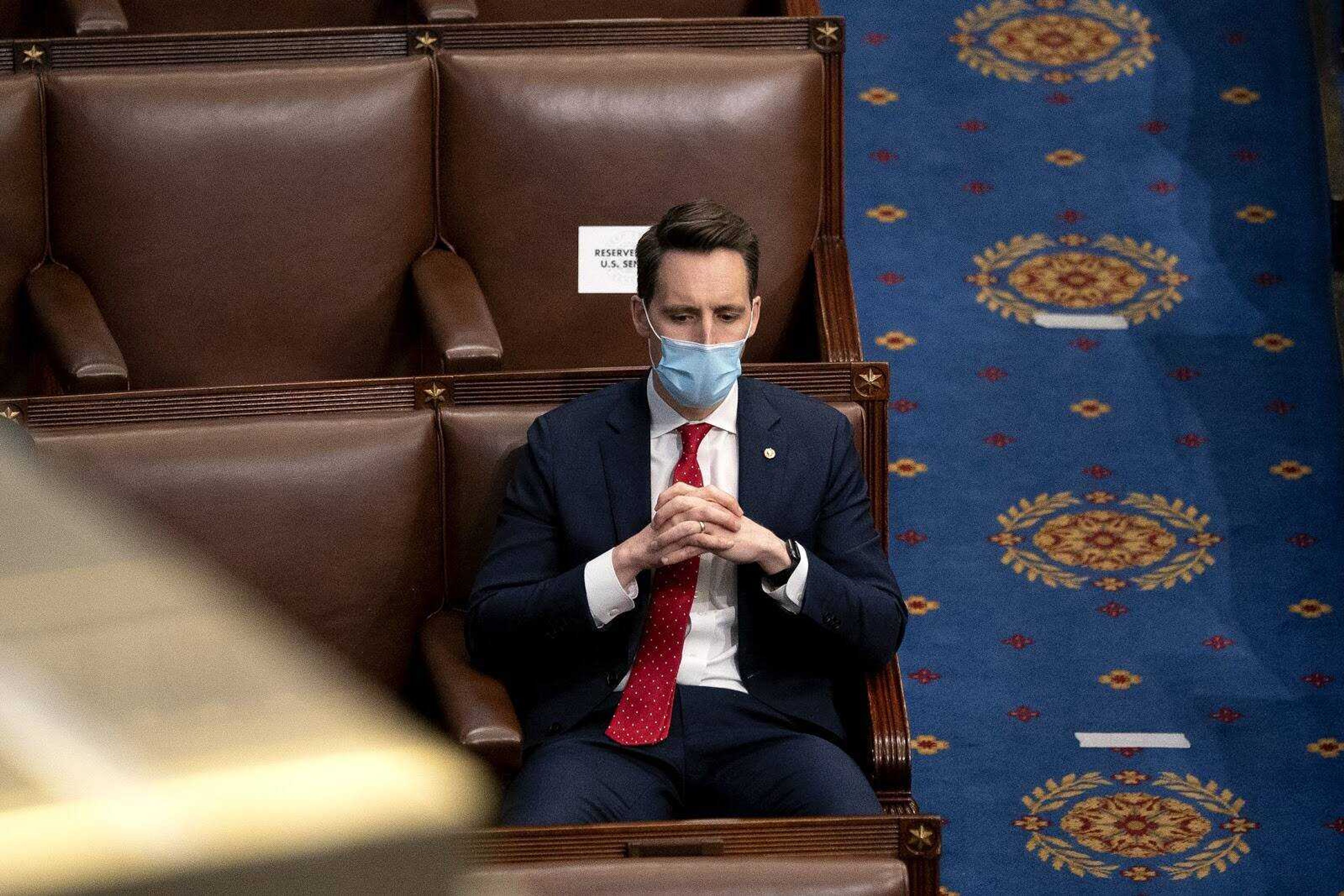 Sen. Josh Hawley sits with folded hands on Jan. 8 on the senate floor. Southeast Democrats are calling for Hawley’s resignation.