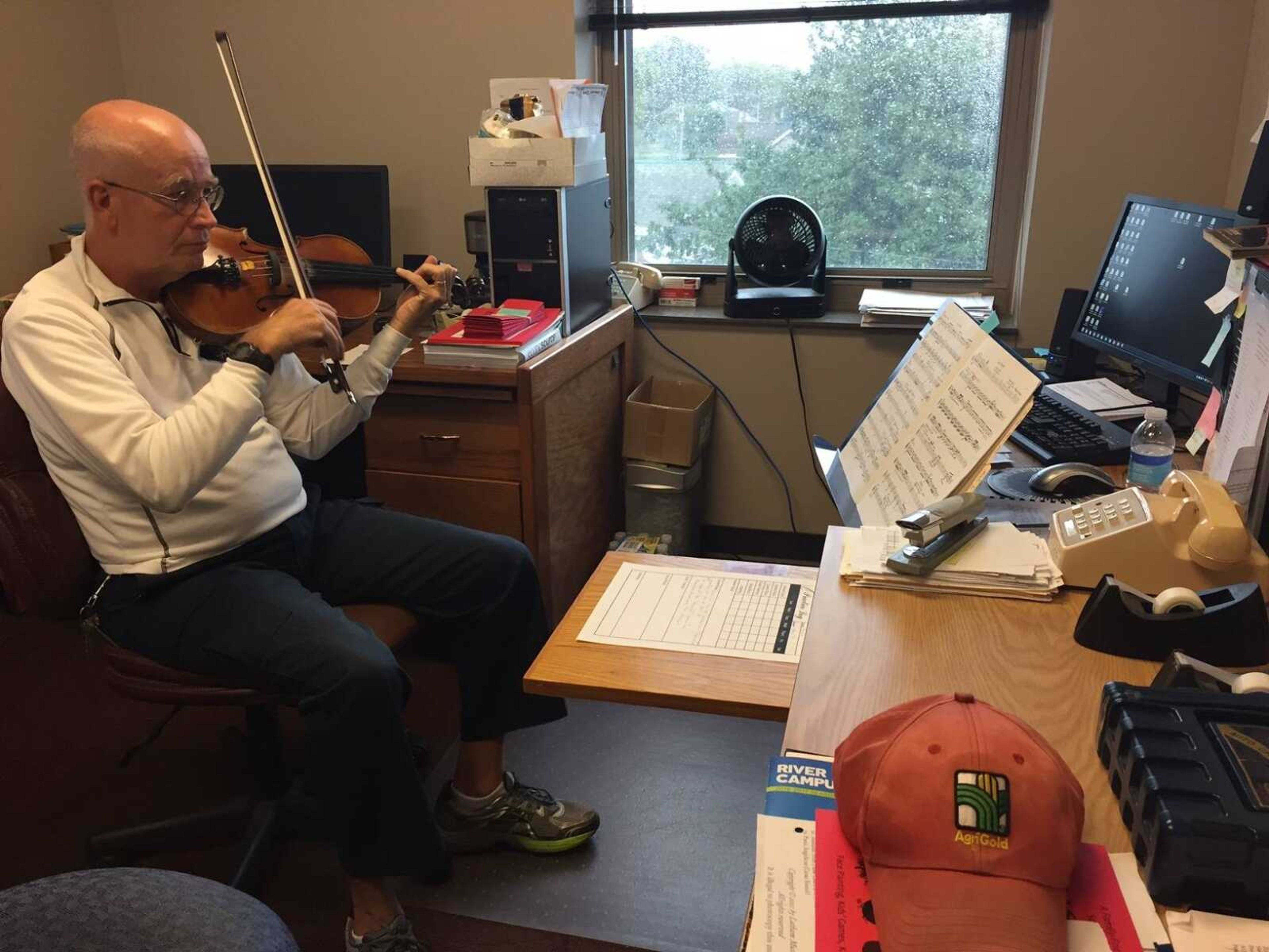 Steve Schaffner, director of the Music Academy practicing the violin in his office.