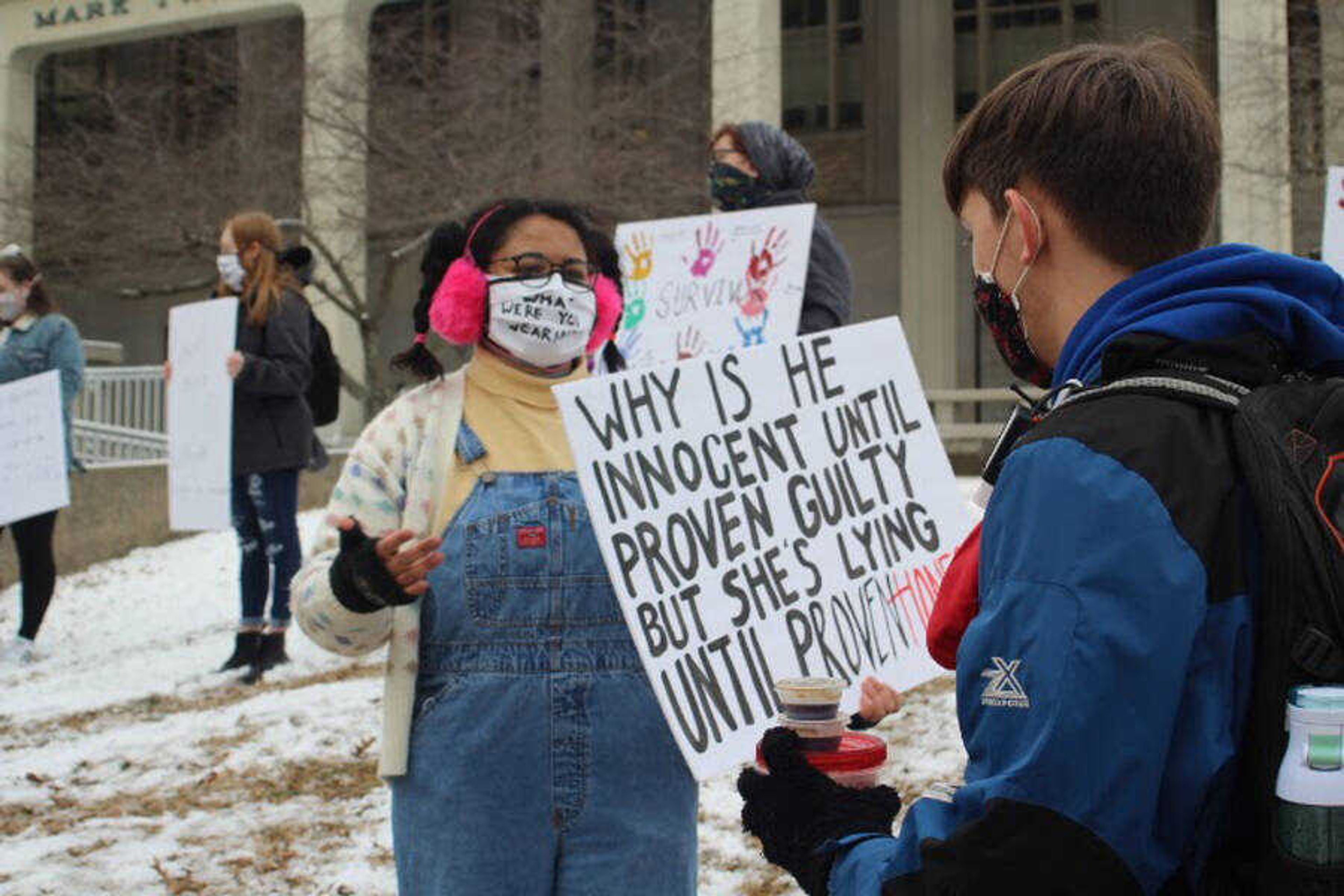 Protest organizer Mahala Pittman discusses the message on her sign with a passerby during a protest Monday against the university’s sexual assault policies. Participants called for Vargas to take actions outlined in a Dec. 16 press release.