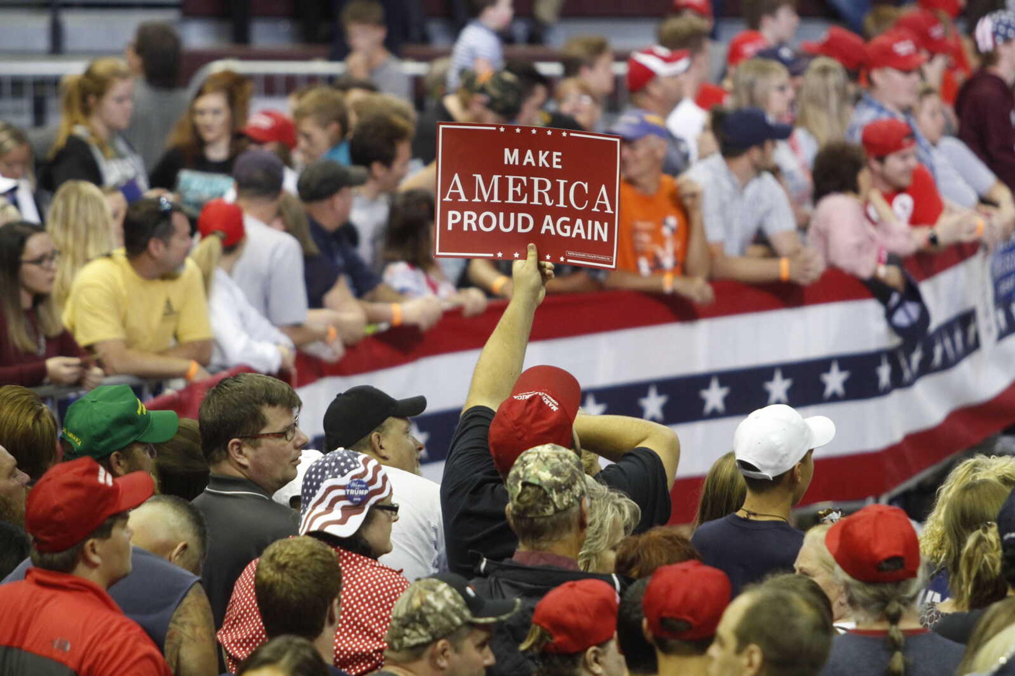 An attendee of President Trump's MAGA rally holds a "Make America Great Again" poster, distributed by Donald J. Trump for President, inc., before the rally started in JQH Arena on Sept. 21.