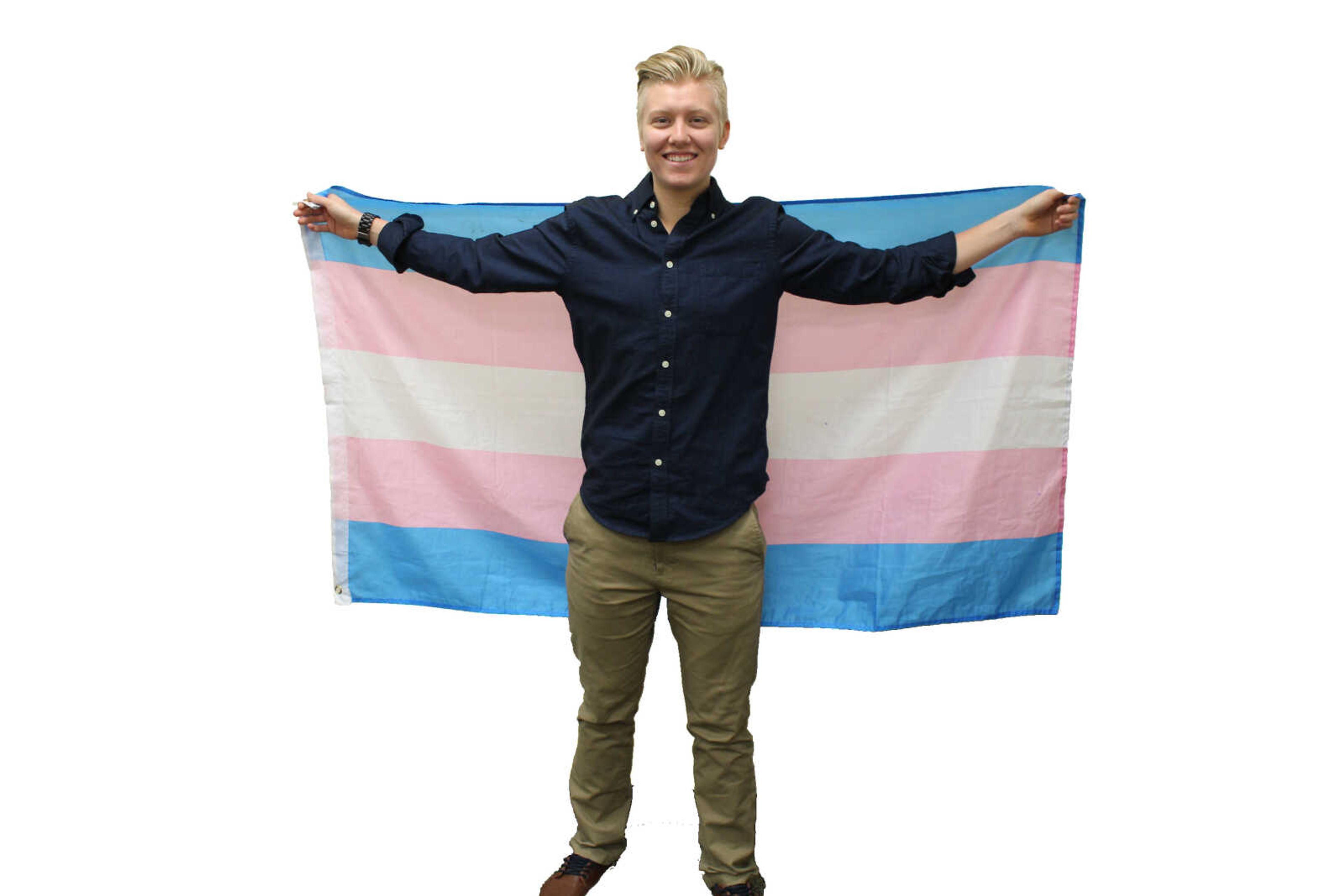 Rane Belling raises the transgender flag behind them in the Center for Student Involvement on March 19, 2018.