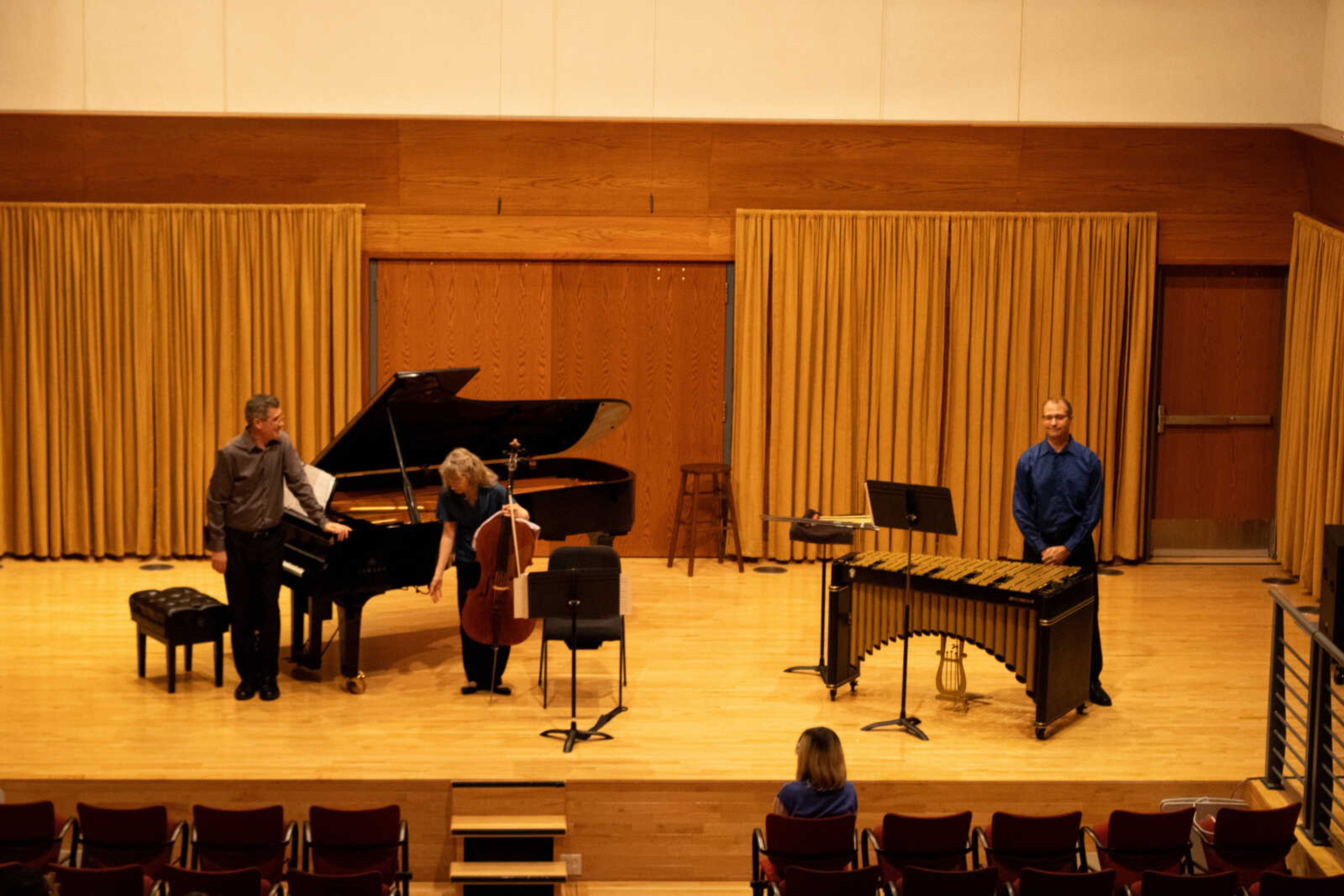 (Left) Music professor Paul Thompson, director of orchestra and low applied strings Sara Edgerton and music professor Shane Mizicko take a bow for the audience in Shuck Recital Hall. The faculty members played through music at the recital on Aug. 29, 2023.
