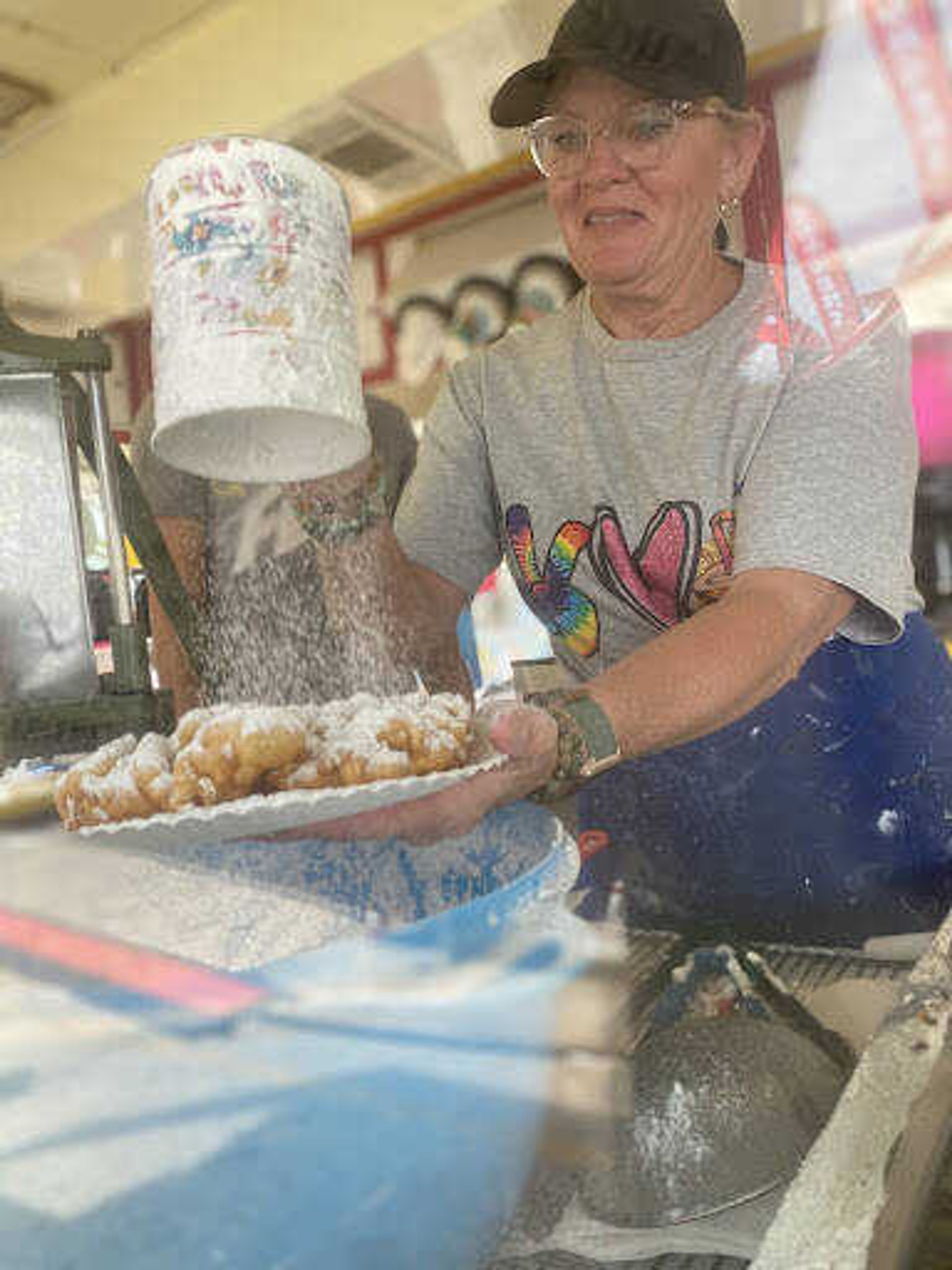 R&R owner Rebecca Motsinger dusts powdered sugar on a funnel cake at the SEMO District Fair. 