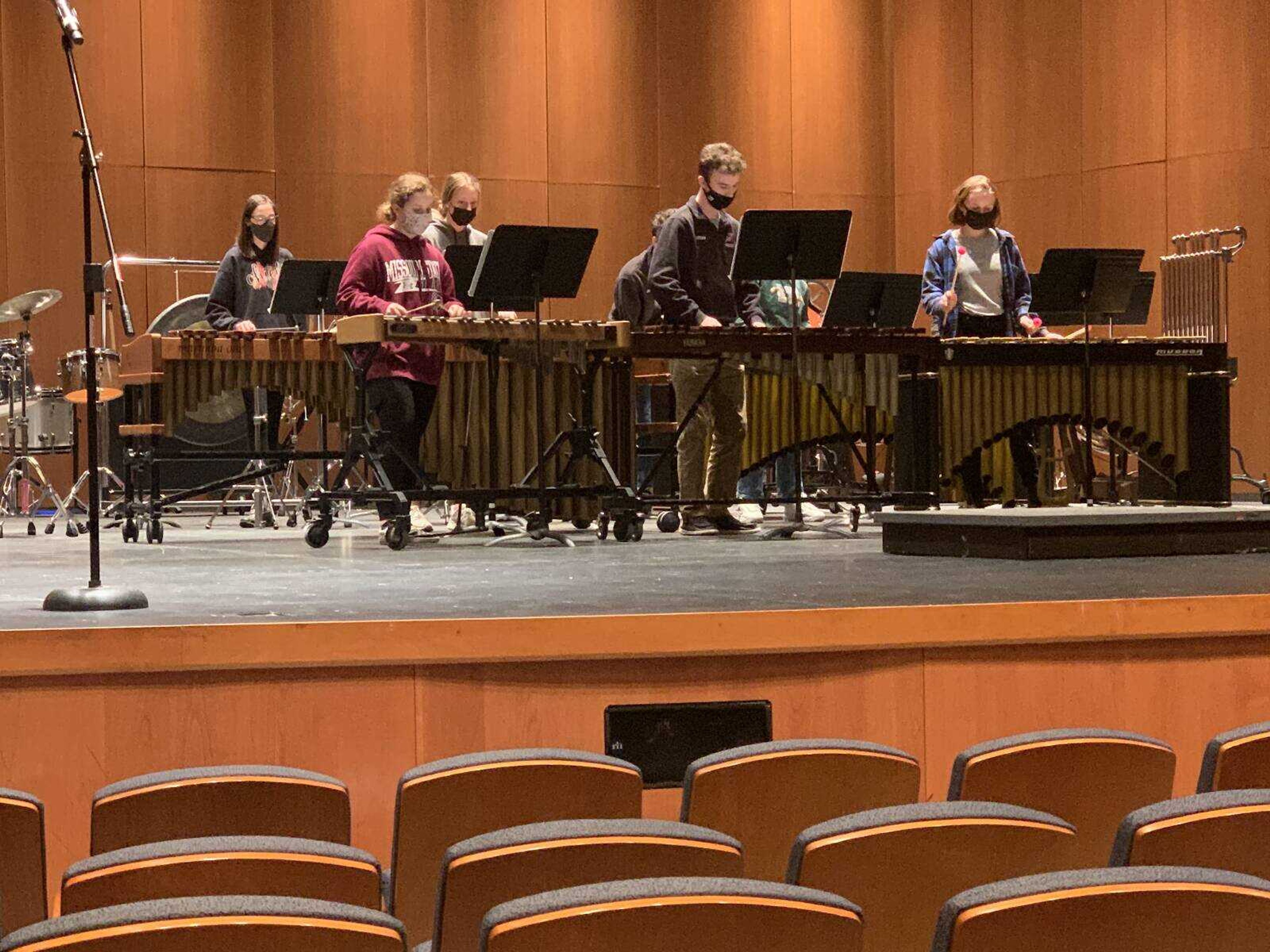 High school ensemble percussion students play in groups at River Campus. 